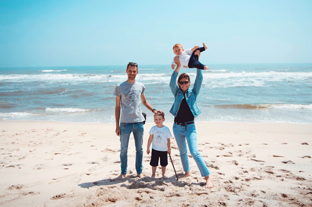 Family-vacation-at-the-beach A man, woman, and their two children at the beach